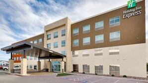 A Holiday Inn Express building with a covered entrance, parking lot, and handicap-accessible parking spaces. - Holiday Inn Express Kermit By IHG (Kermit)
