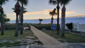 Stroll along the palm-lined pathway to Cocoa Beach, where a serene atmosphere awaits.