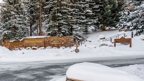 A snow-covered road with a sign for 'StreamSide at VAIL' and 'Marriott Vacation Club' in the background.