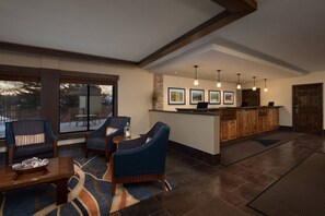 A spacious living area with a large window, a reception desk, and a fireplace.