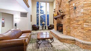 A cozy living room with a stone fireplace, leather sofa, and a coffee table. - Marriotts Streamside at Vail - 1 Bedroom (Vail)