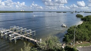Un puerto deportivo con muelles, barcos y una vista despejada del agua y edificios al fondo.