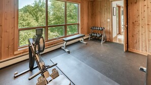 A gym with a rowing machine, dumbbells, and a bench. - Only 5 minutes away from Stratton Mountain  (Winhall)