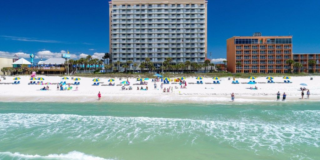 A beach with a hotel in the background.