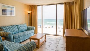 Une chambre d’hôtel avec une grande fenêtre, un canapé, une table basse et un téléviseur.