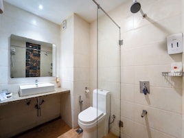 Un baño con lavabo, inodoro, ducha y espejo.