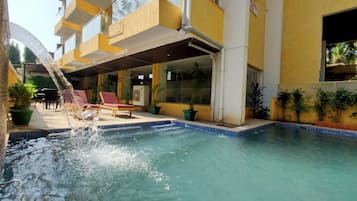 Alberca al aire libre y camastros