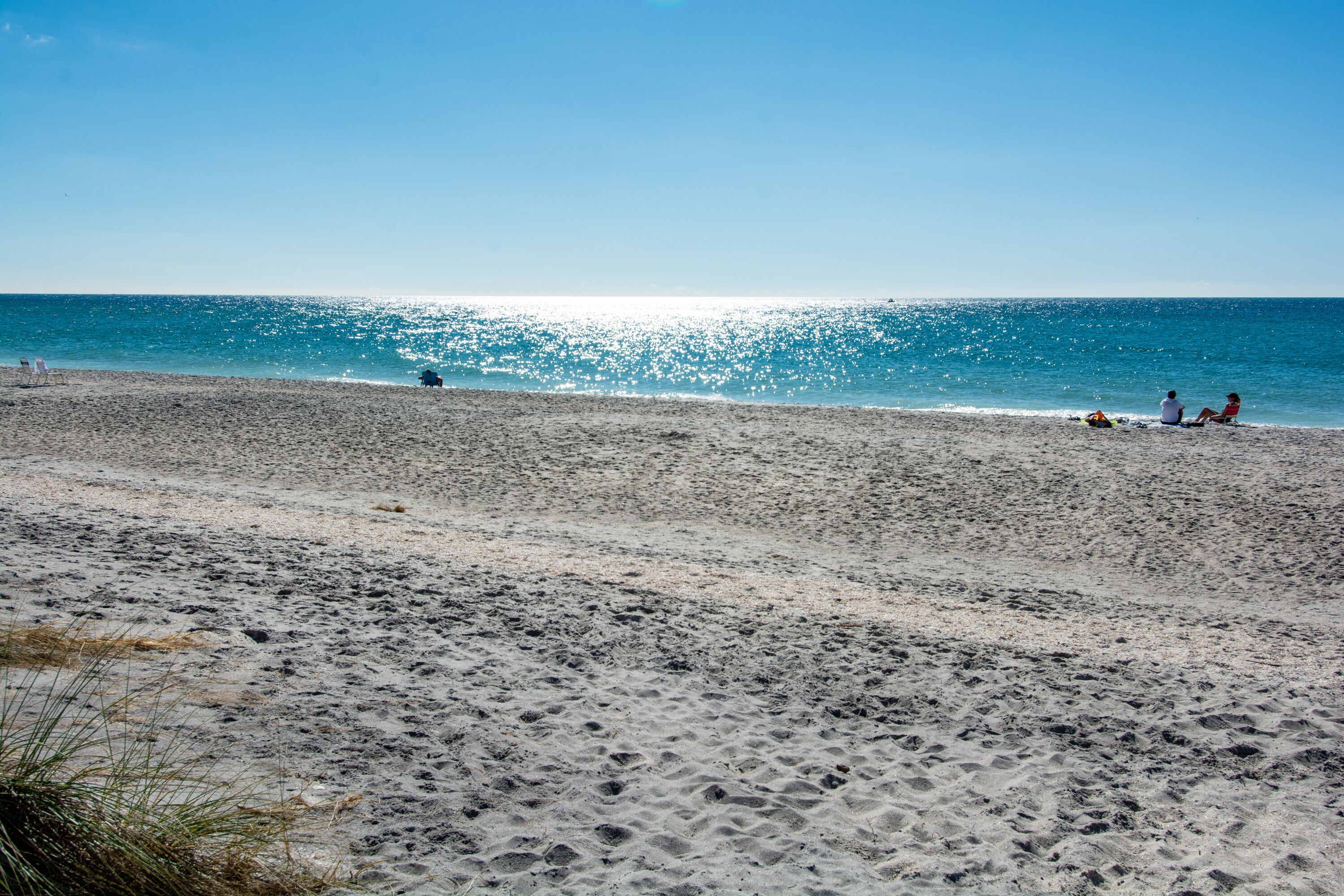 A beach with a clear sky and calm sea.