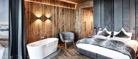 A modern bedroom with a large bed, a built-in bathtub, and wooden paneling.