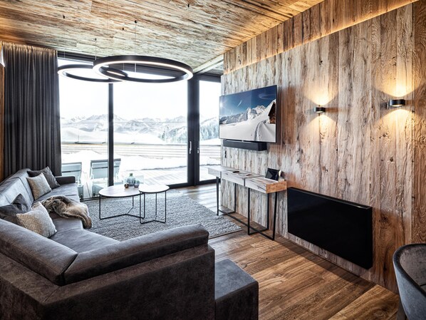 Relax in this stylish living room with a large sectional sofa, flat-screen TV, and fireplace.