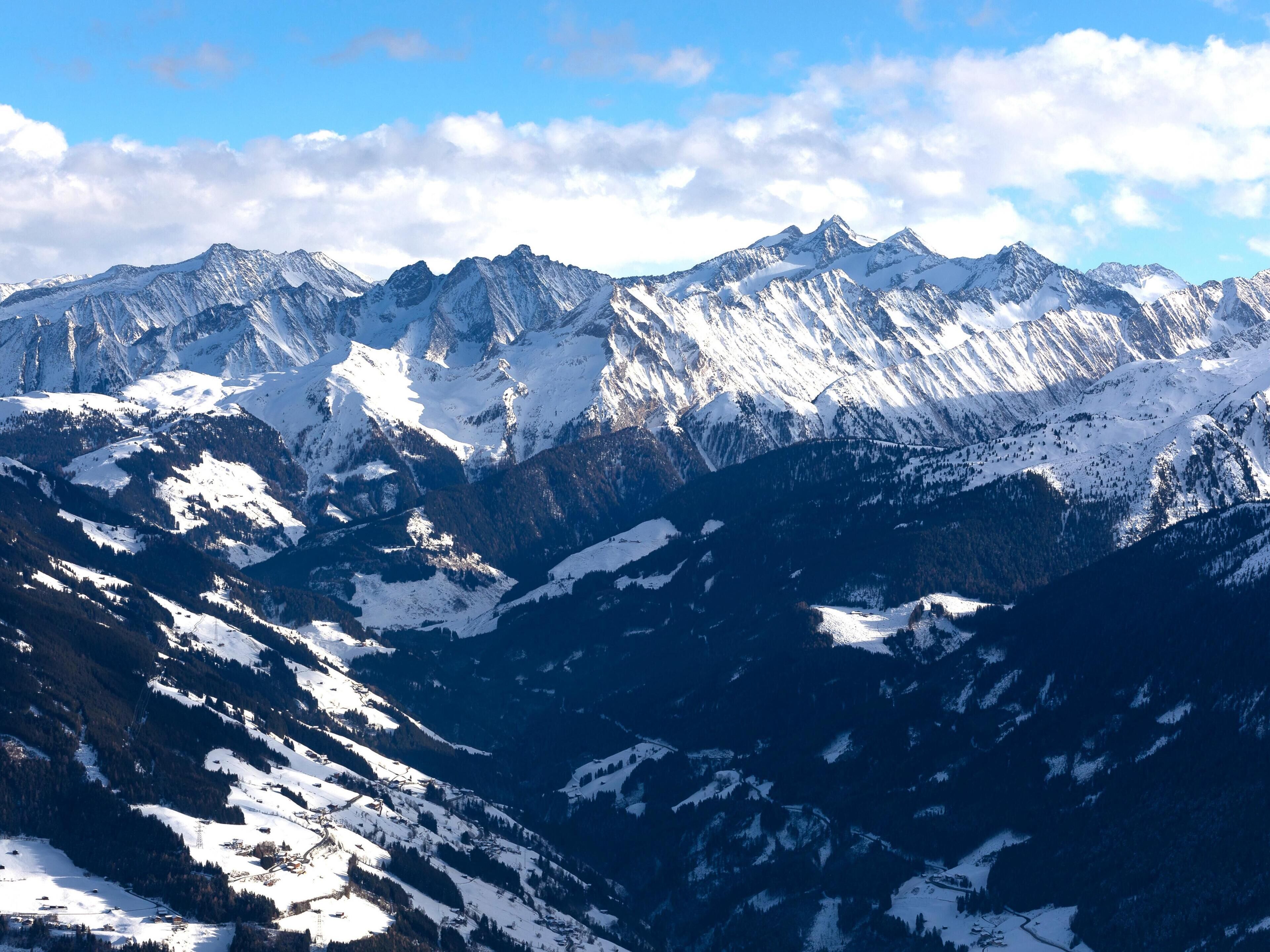 A mountain landscape with snow-covered peaks and a clear sky.