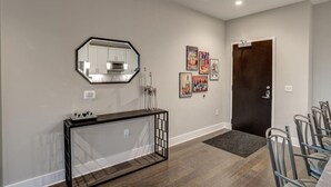 A hallway with a console table, a mirror, and framed artwork on the wall.