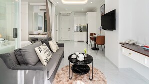 A modern living room with a sofa, a coffee table, and a TV mounted on the wall.