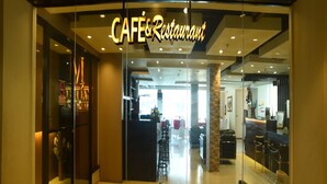 A cafe and restaurant with a glass facade, interior seating, and a visible counter area. - Marcian Business Hotel (Zamboanga)