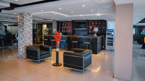 A modern lobby with a bar area, seating, and a decorative pillar. - Marcian Business Hotel (Zamboanga)