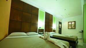 A hotel room with two beds, a large mirror, and a green wall. - Marcian Business Hotel (Zamboanga)