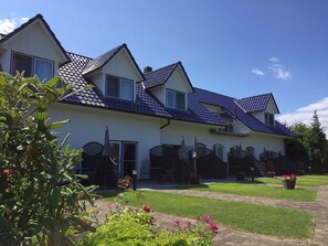 A two-story house with a tiled roof, a front door, and a small balcony. - App. 602 - Apartment complex Zur Seemöwe (Ostseebad Insel Poel)