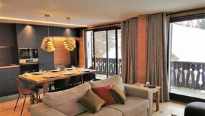 Un salon moderne comprenant un canapé, une table à manger et un coin cuisine.