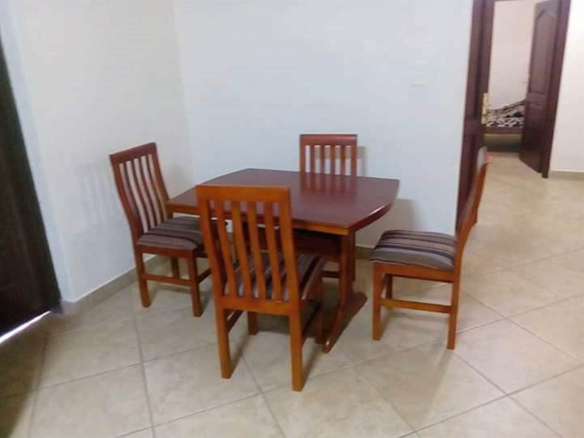 A dining area with a wooden table and four chairs.