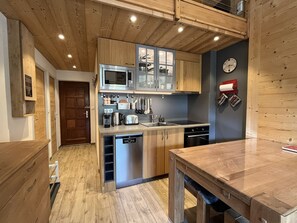 Una cocina moderna con armarios de madera, electrodomésticos de acero inoxidable y lavavajillas integrado.