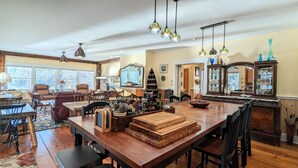 A spacious kitchen with a large island, wooden furniture, and pendant lighting. - 1/4 Acre Woods on Lake Waukewan! (Meredith)