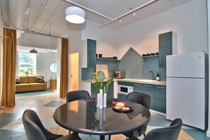 Eine moderne Küche mit Essbereich, ausgestattet mit einem runden Tisch, Stühlen und einem Kühlschrank.