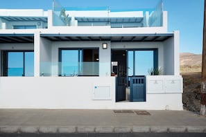 Un bâtiment moderne à deux étages, doté de grandes fenêtres en verre, d’un toit plat et offrant une vue dégagée sur le paysage environnant.