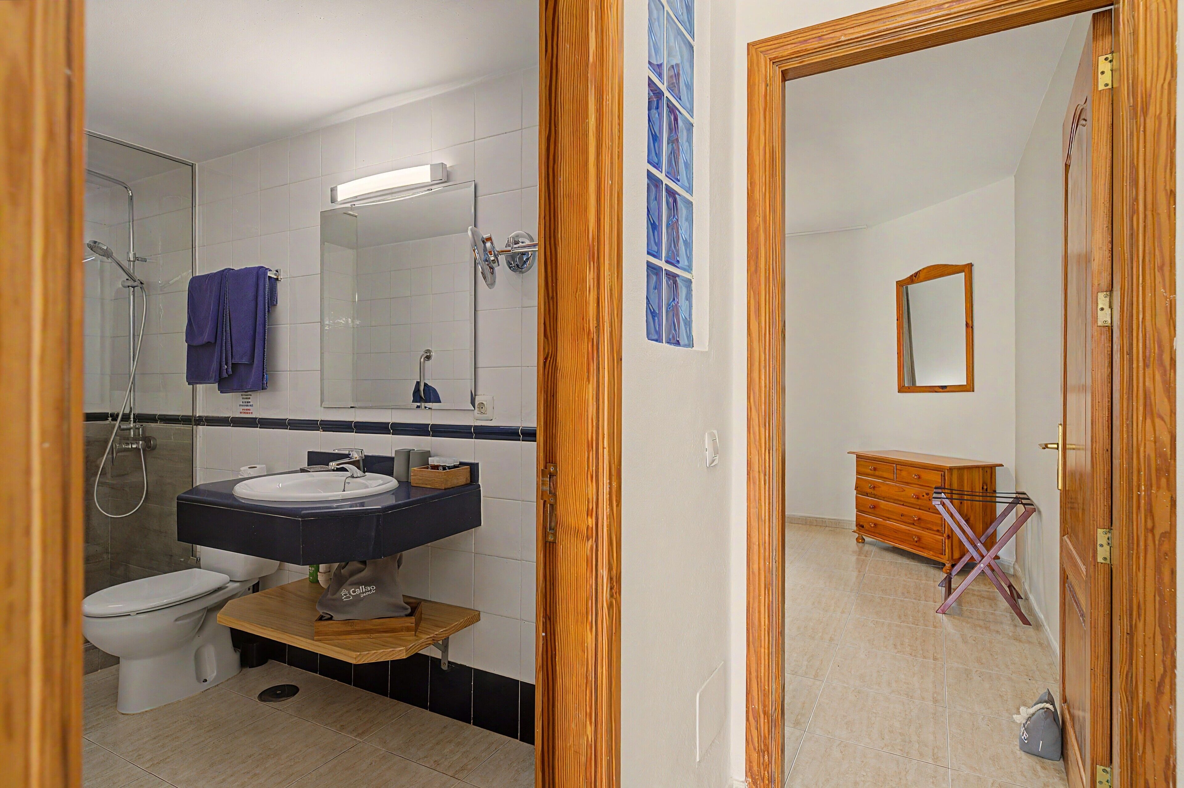 Un baño con ducha, inodoro, lavabo y espejo.