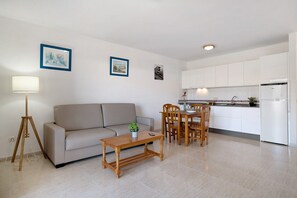 A modern living room with a sofa, coffee table, and dining area. - Holiday Apartment “Callao Beach 10” with Mountain View, Terrace & Wi-Fi (Arrieta)