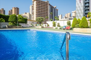 Una piscina con un paisaje urbano al fondo.