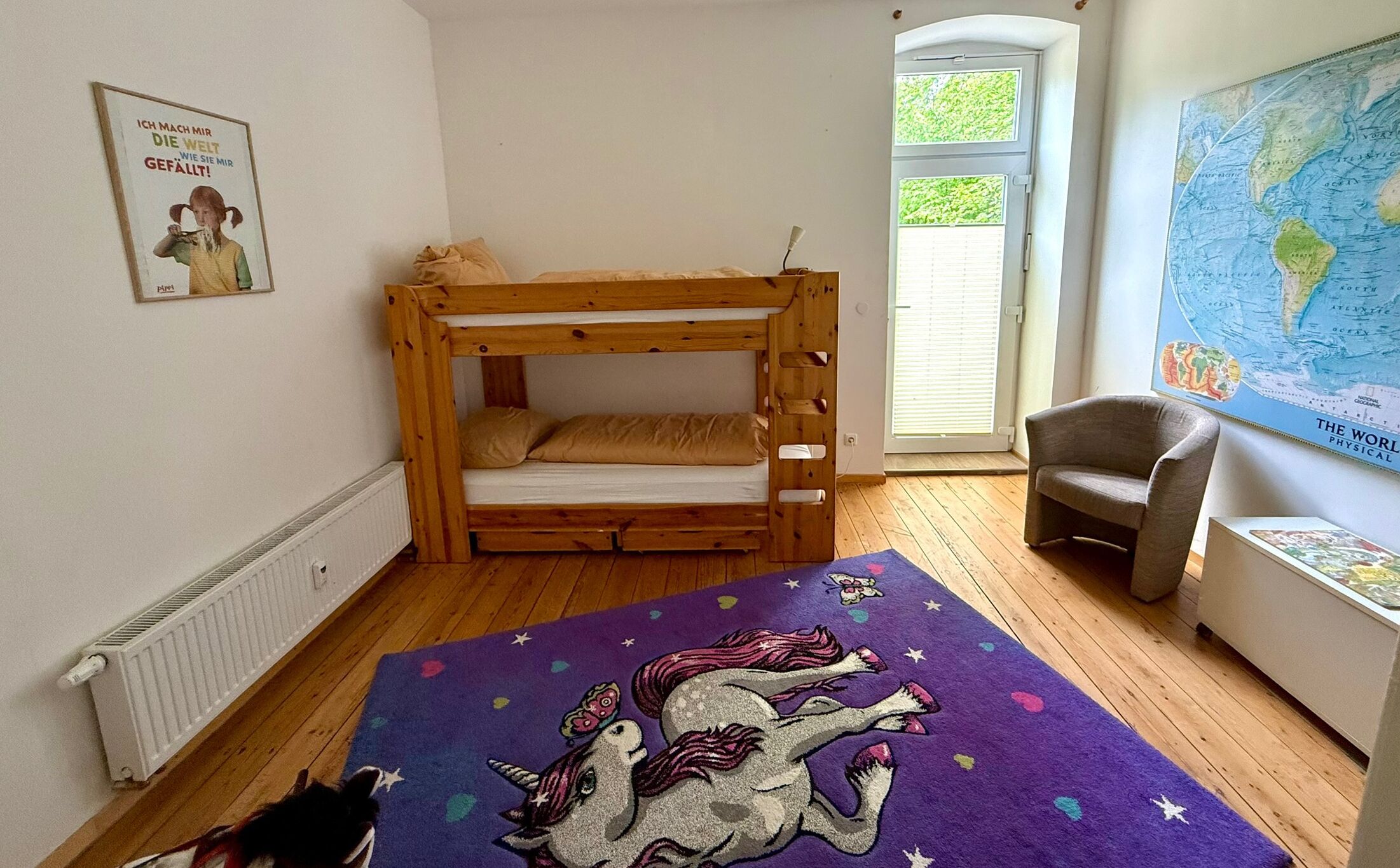 Un dormitorio infantil con literas, un globo terráqueo y un mapa en la pared.