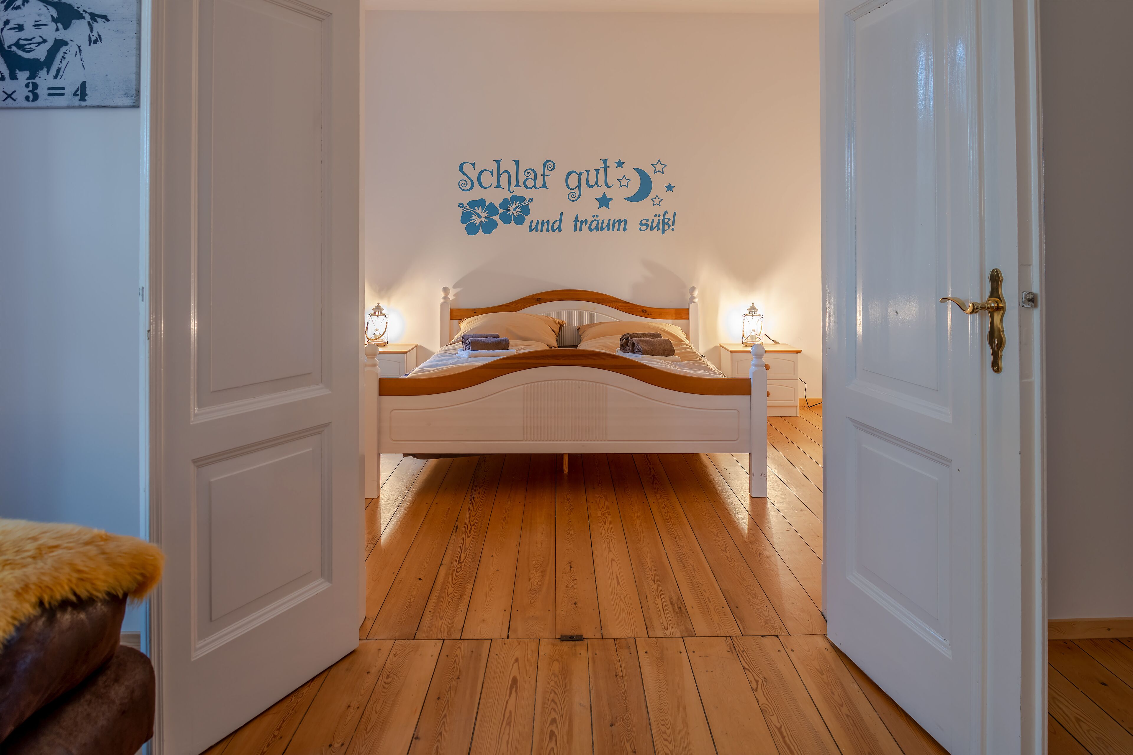 A bedroom with a bed, bedside tables, and a wall decoration.