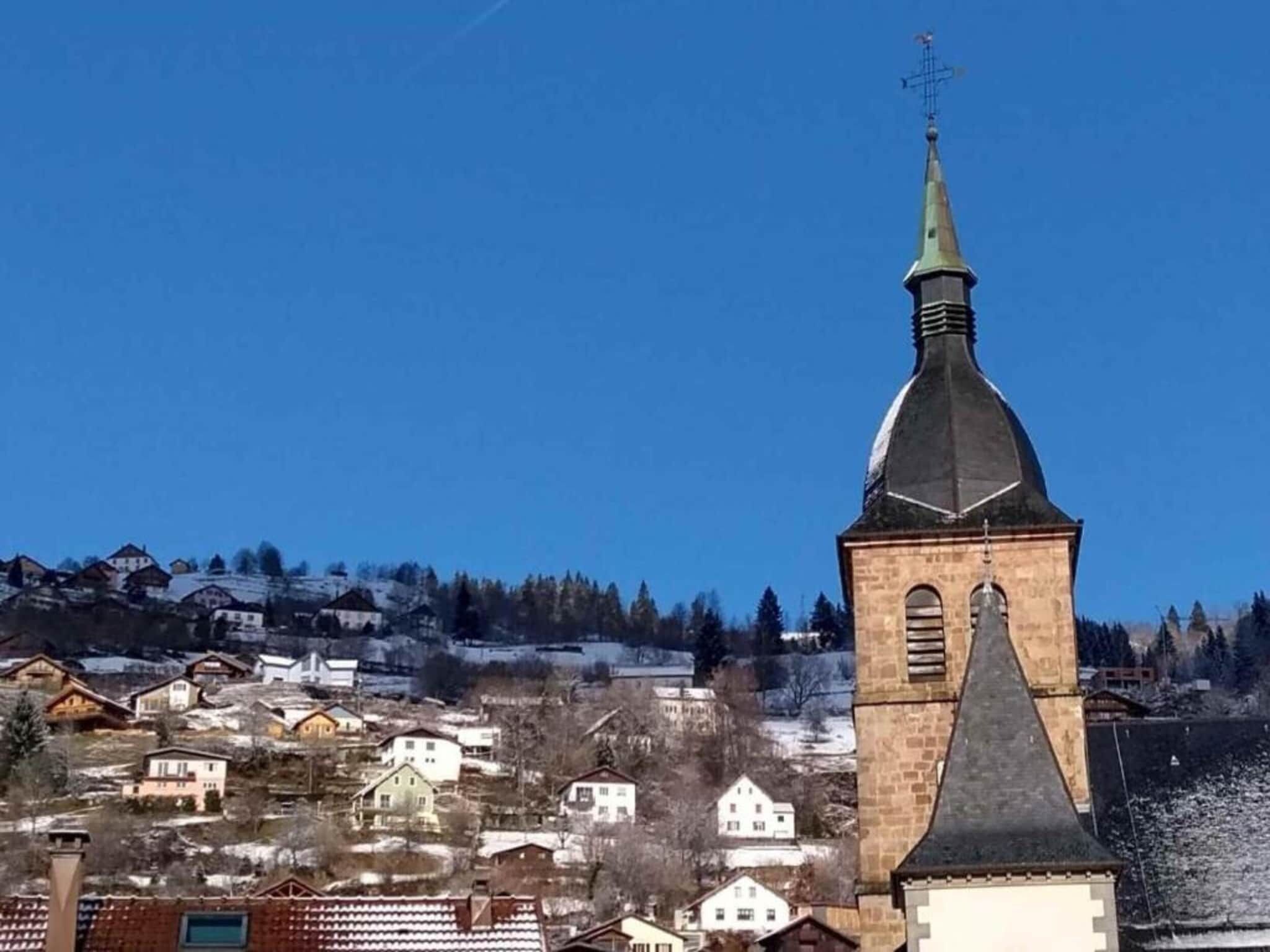 A church with a tall steeple and a clock tower.