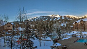 A resort with a pool, snow-covered mountains, and lodge buildings. - Ski-In/Ski-Out Luxury at Grand Timber Lodge – Breckenridge, CO (Breckenridge)