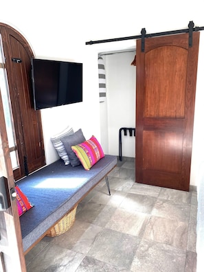 Relax in a cozy space with a bench and flat-screen TV.