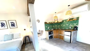 A compact living space with a kitchenette, a bed, a dining area, and a small seating area. - Loreto80-NEW Studio Palma, in downtown by beach (Loreto)