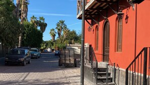 A cobblestone street lined with parked cars and palm trees. - Loreto80-NEW Studio Palma, in downtown by beach (Loreto)