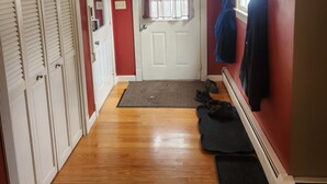 A hallway with wooden flooring, a white door with a window, and a coat rack with jackets. - Skiing, snowshoeing, snowmobile/ATV trails, hunting, hiking and kayaking (Rumford)