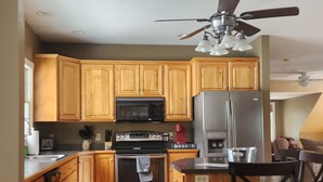 A kitchen with wooden cabinets, a microwave, a refrigerator, a stove, and a ceiling fan. - Skiing, snowshoeing, snowmobile/ATV trails, hunting, hiking and kayaking (Rumford)
