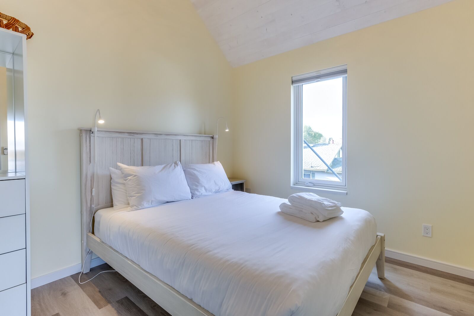 A bedroom with a bed, a window, and a wardrobe.