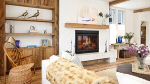 A cozy living room with a fireplace, wooden shelves, and comfortable seating. - Splendid Home in the Heart of Telluride Town (Telluride)