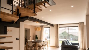 Un intérieur moderne comprenant un escalier, un coin repas et un salon avec un canapé.