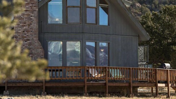 A two-story house with a prominent brick chimney, large windows, and a wooden deck. - Rhode's Hideaway- Dog Friendly, Minutes to Salida, Close to Monarch (Salida)