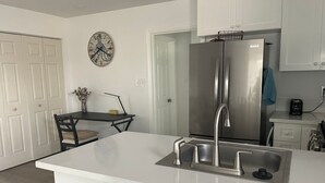 A modern kitchen with a stainless steel refrigerator, a white countertop, and a sink. - Yard, Dog, & Kid Friendly! -Blue Whale Inn #C (San Clemente)
