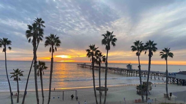 A beach with palm trees, a pier, and a sunset. - Yard, Dog, & Kid Friendly! -Blue Whale Inn #C (San Clemente)