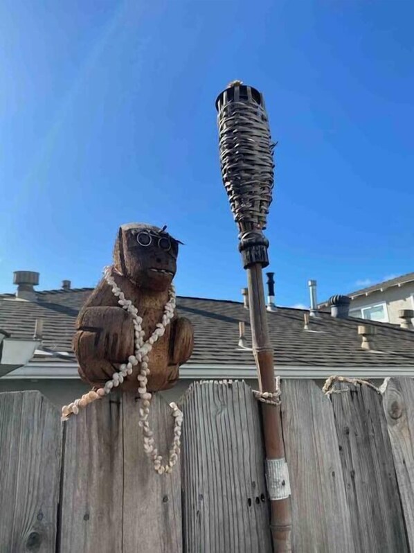 A wooden fence with a decorative figure holding a tiki torch. - Yard, Dog, & Kid Friendly! -Blue Whale Inn #C (San Clemente)