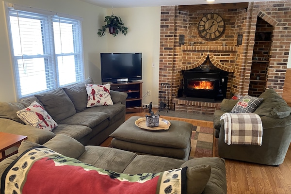 Living room #1 has wood stove fireplace and large flat screen TV.