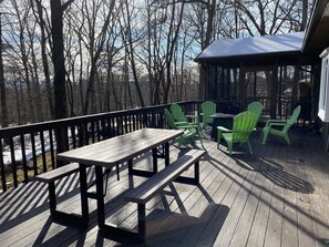 Relax on the outdoor deck, surrounded by nature, with comfortable seating and a dining area.