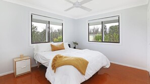 A bedroom with a bed, two windows, a nightstand, and a ceiling fan. - The Hamilton - Kangaroo Valley (Budgong)