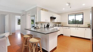 A modern kitchen with white cabinetry, a large island, and a window providing natural light.